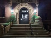 Photo of City Hall with green entry lights in honor of Veterans Day