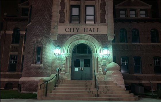 photo of City Hall with green lights for Veterans Day